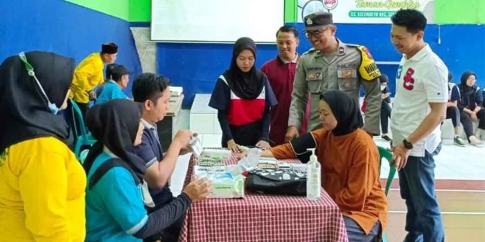 Bhabinkamtibmas Sidomulyo, Aipda Himawan Pratama, saat ikut memantau pemeriksaan kesehatan. Foto: Ist
