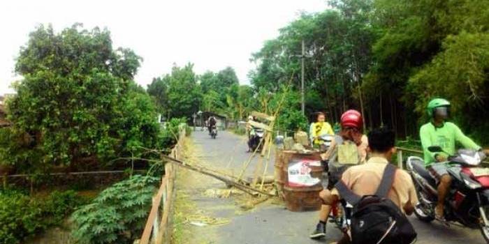 Warga setempat memberi rambu seadanya di bagian jembatan yang berlubang. foto: dendi martoni/BANGSAONLINE