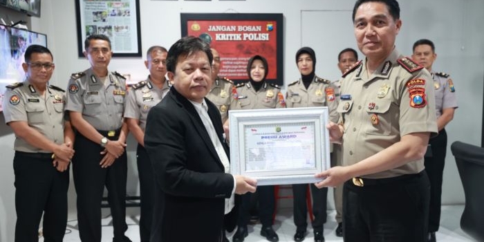 Kabid Humas Polda Jatim saat menerima penghargaan 