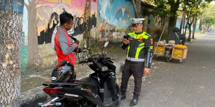 Petugas Satlantas Polres Nganjuk saat melakukan penindakan ETLE Handheld terhadap pemotor yang nekat melawan arus