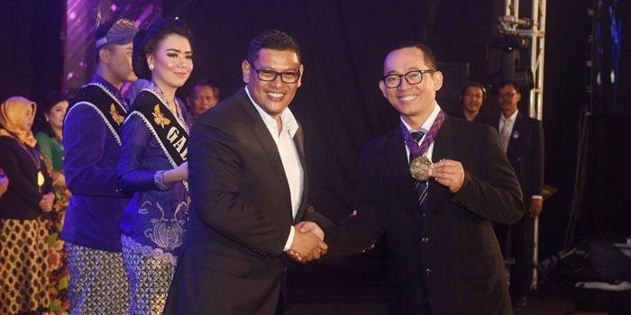 Wali Kota Kediri saat menyerahkan medali kepada salah satu warga berprestasi.