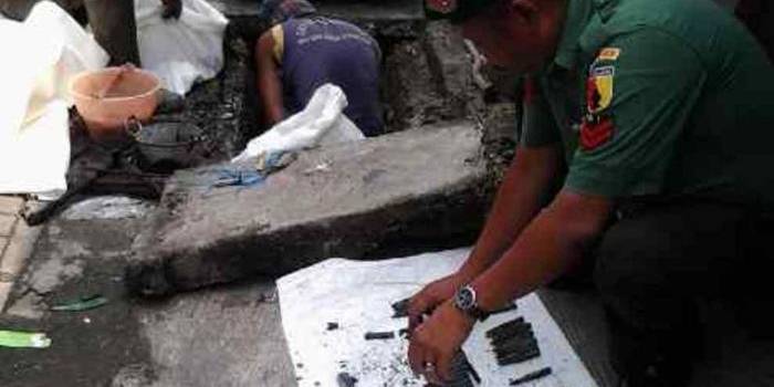 Petugas mengevakuasi 46 peluru aktif yang ditemukan di selokan di Jalan KH Mas Mansyur, Surabaya, Selasa (11/3/2014). Foto: Rusmiyanto/Bangsaonline.com