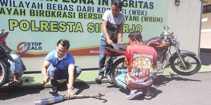 Nampak pemilik kendaraan harus rela menghancurkan sendiri knalpot racing miliknya di hadapan polisi.