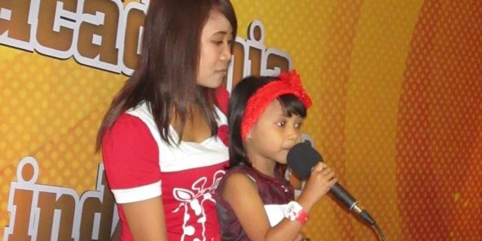 AKADEMI. Salah satu peserta La Academia Junior Indonesia Eiffeleen Princess Rosana dipangku ibunya. foto : nisa/bangsaonline