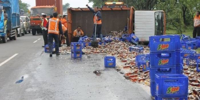 Truk yang terguling hingga isinya meluber ke jalan tol. foto: Nanang Ichwan/BangsaOnline.com