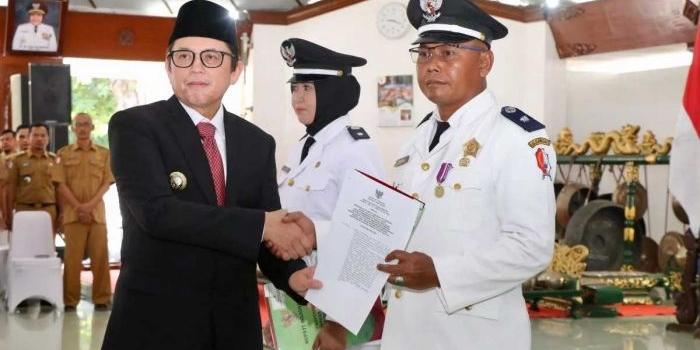 Ketua AKD Kabupaten Bojonegoro Sudawam (kanan) menerima SK perpanjangan masa jabatan kades dari Pj Bupati Bojonegoro Adriyanto (kiri) di Pendapa Pendapa Malowopati Bojonegoro, Senin (10/6/2024). Foto: Dok. Humas Pemkab Bojonegoro