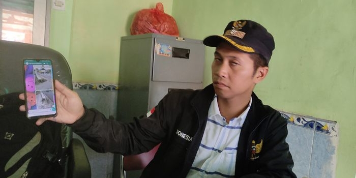 Abu Dawud, Kades Bakung Temenggungan ketika menunjukan chat WA dengan pelaksana proyek drainase. foto: YUDI EKO PURNOMO/ BANGSAONLINE