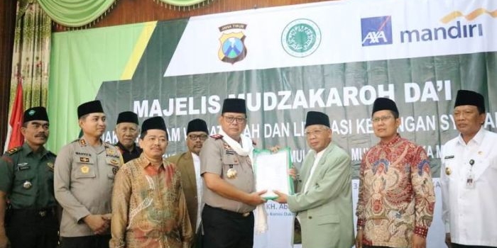 Kapolda Jatim Irjen Pol Luki Hermawan menerima buku dari Ketua MUI Jatim KH Abdus Shomad Buchori. foto: Syuhud/bangsaonline.com
