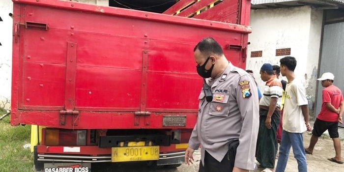 Petugas sedang menunjukkan bagian belakang truk yang ditabrak korban.