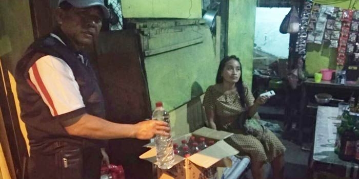 Petugas menunjukkan miras yang disimpan dalam kardus.