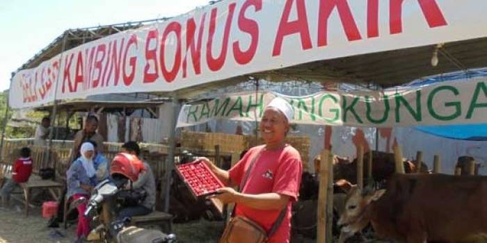 Sururi Rochimin menunjukkan batu akik sebagai cindera mata bagi konsumen hewan qurban di stannya. foto: devi fitri afriyanti/BANGSAONLINE
