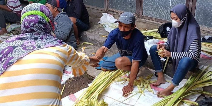 Abdullah, salah satu pedagang ketupat di Pasar Gurah saat melayani pembeli. foto: MUJI HARJITA/ BANGSAONLINE