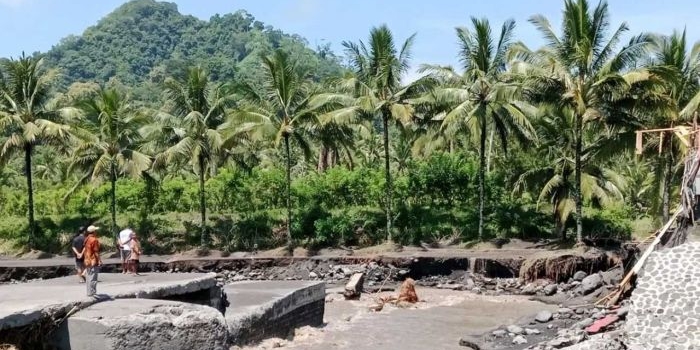 Sejumlah warga melihat Jembatan Gondoruso di Kecamatan Pasirian yang terputus akibat banjir lahar dingin Gunung Semeru pada Jumat (19/4/2024).