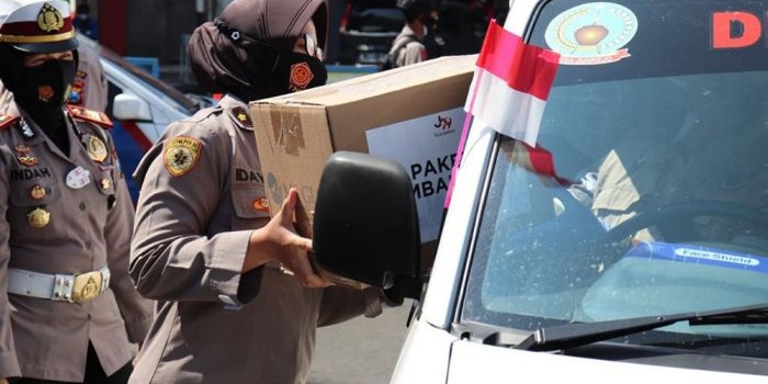 Kasatlantas Polres Batu, AKP Indah Citra Fitriani saat mebagikan paket sembako kepada sopir ambulans.