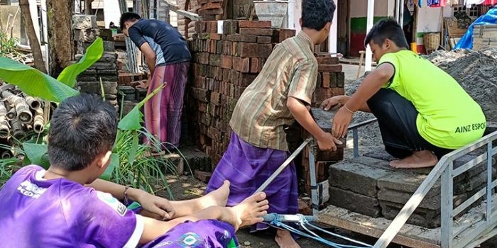 Para santri laki-laki saat ikut membantu mengangkat material di lokasi pembangunan Ponpes Mifa yang baru.
