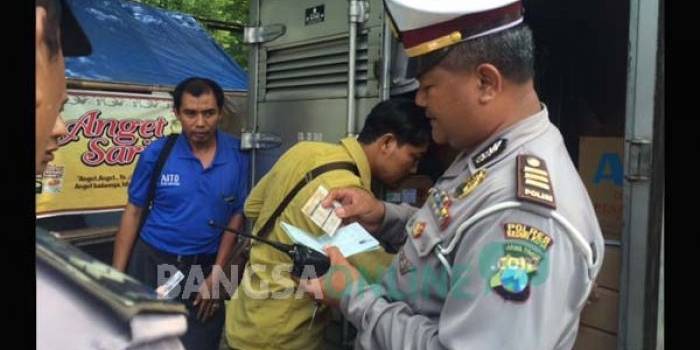 Petugas kepolisian saat memeriksa barang bawaan kendaraan roda empat yang melintas di jalan Ahmad Yani Kota Kediri. foto: arif kurniawan/ BANGSAONLINE
