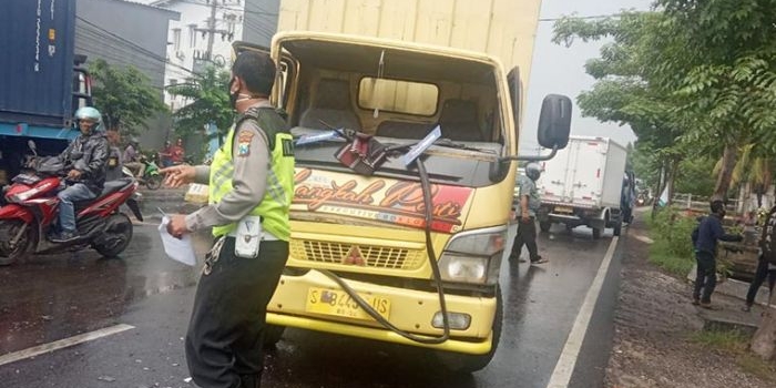 Petugas dari Satlantas Polresta Sidoarjo mengurai arus lalu lintas yang macet setelah terjadinya kecelakaan. 