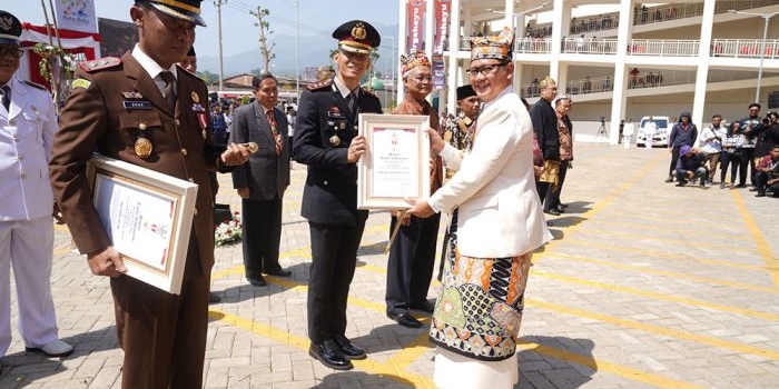 Pj. Wali Kota Batu Aries Agung Paewai saat menyerahkan piagam tanda kehormatan berupa Lencana Wakaryo Guno Mamayu Bawono.