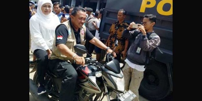 Menteri Sosial, Khofifah Indar Parawansa menumpang sepeda motor untuk menjangkau lokasi longsor yang tidak bisa dilewati kendaraan roda empat.