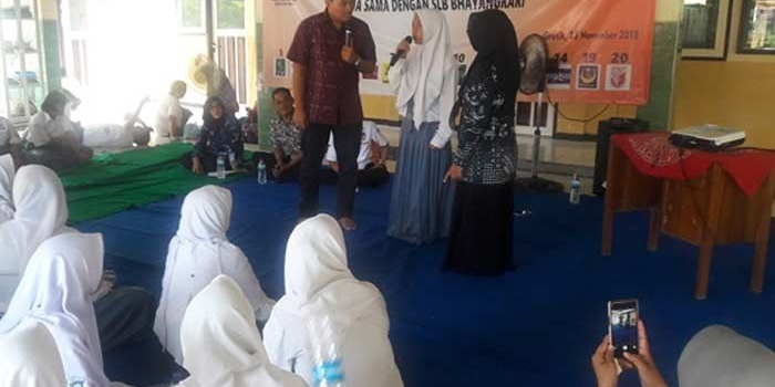 Makmun, Divisi Sosialisasi KPU Gresik saat sesi kuis berhadiah dalam sosialisasi kepemiluan kepada siswa disabilitas. foto: SYUHUD/ BANGSAONLINE