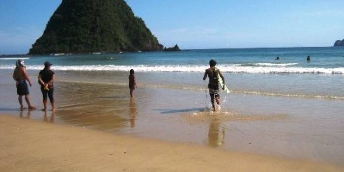 Wisatawan sedang menikmati indahnya pemandangan pantai Pulau Merah.foto:franciscus wawan slamet/BANGSAONLINE