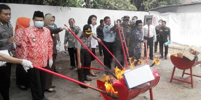 Pemusnahan BB narkotika, obatan-obatan terlarang serta miras dan sejumlah alat bukti kejahatan oleh Kejari Mojokerto. Pemusnahan ini disaksikan jajaran forkompimda setempat.  foto: YUDI EP/ BANGSAONLINE
