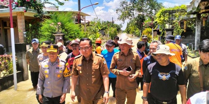 Wakil Bupati Gresik, Asluchul Alif (dua dari kiri), bersama Kapolres Gresik, AKBP Rovan Richard Mahaneru, saat meninjau lokasi banjir luapan Kali Lamong. Foto: Ist.
