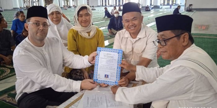 Timothy John Rogerson (kiri) memegang surat pernyataan masuk Islam yang baru ditandatangani bersama Dr KH M Sujak, M.Ag (kanan) di Masjid Al-Akbar Surabaya, Selasa (12/3/2024). Foto: masjidalakbar.or.id 