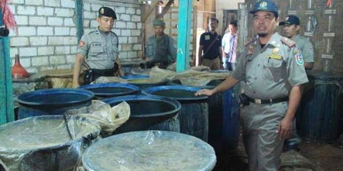 KELAS KAKAP: Plh Kasatpol PP, Wadiono, saat menunjukkan barang bukti baceman atau bahan arak yang siap dimasak. foto: suwandi/ BANGSAONLINE