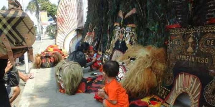 Nampak beberapa warga sedang memfotokan anaknya bersama reog yang dijemur. (foto: dendi martoni/BANGSAONLINE)