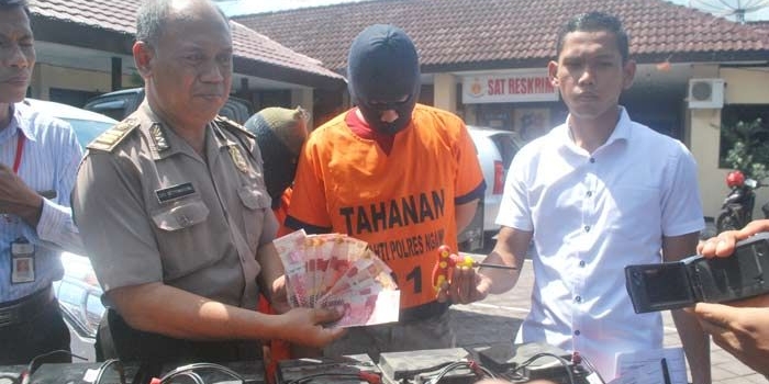 Pasutri saat di kantor Polres Ngawi bersama barang bukti berupa baterai dan sejumlah uang.