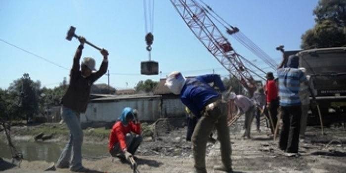 ?

Pekerja proyek tengah menggempur Jembatan Tulangan dengan cara manual. foto:daryanto/BANGSAONLINE