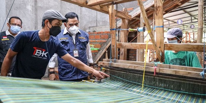 Erwin Wahyu Nugroho dan Kepala Disperdagin Jatim, Drajat Irawan, saat melihat proses pembuatan tenun ikat di Kampung Tenun Ikat, Bandar Kidul, Kota Kediri. Foto: Ist