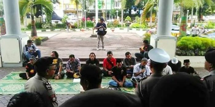 Aksi sejumlah aktivis saat menggelar tahlil dan membaca surat yasin di depan gedung DPRD Jember.