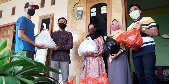 Ahmad Harun dari Relawan Muda Kediri (kiri) saat menyerahkan bantuan secara simbolis dan diterima oleh Septian dan kawan-kawannya. foto: MUJI HARJITA/ BANGSAONLINE