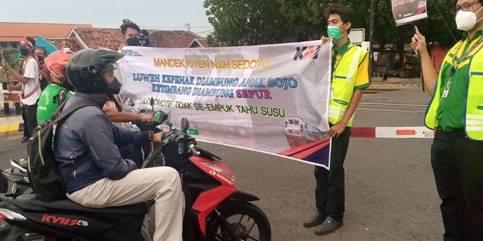 Aksi para komunitas pecinta kereta api saat mensosialisasikan program keselamatan di perlintasan sebidang.