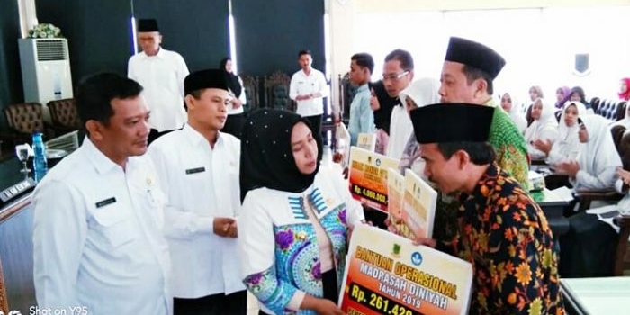 Wali Kota Mojokerto Ning Ita menyerahkan bantuan pendidikan bagi 12 mahasiswa berprestasi, honorarium 116 GTT-PTT, dan BOB Madin Madrasah di Kota Mojokerto. Ia meyakinkan bantuan akan berkelanjutan. foto: YUDI EP/ BANGSAONLINE 