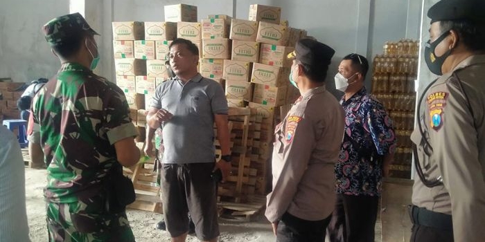 Petugas gabungan dari Polsek dan Koramil Mojoroto saat menemukan tumpukan minyak goreng di sebuah gudang. foto: MUJI HARJITA/ BANGSAONLINE