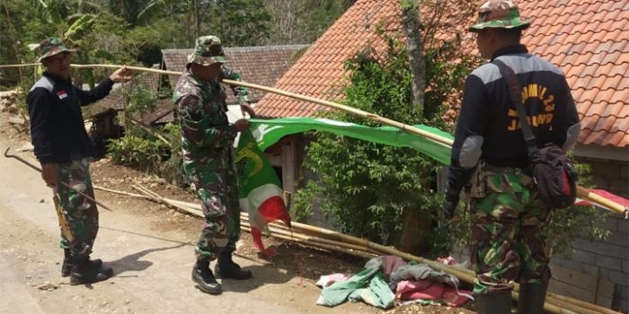 Satgas TMMD Reguler ke-106 Kodim Malang-Batu saat memasang umbul-umbul.