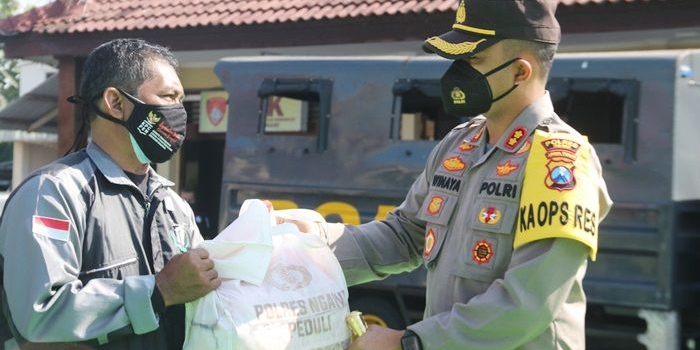 Kapolres Ngawi AKBP I Wayan Winaya menyerahkan bantuan kepada masyarakat.