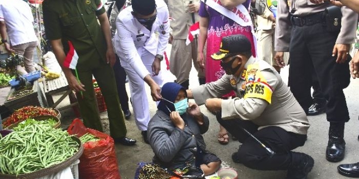 Salah seorang warga di pinggir jalan menerima pembagian masker. 