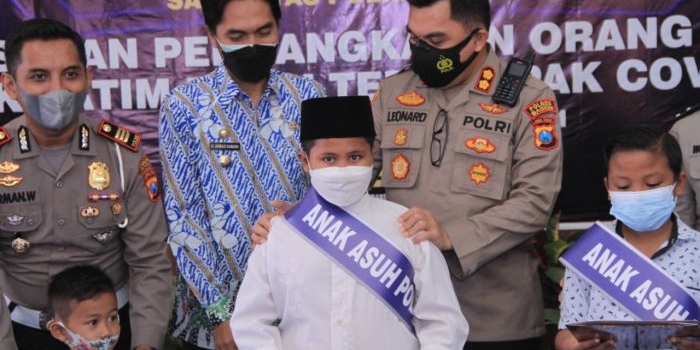 Kapolres Madiun AKBP Jury Lenonard saat mengangkat anak yatim korban Covid-19 secara simbolis.