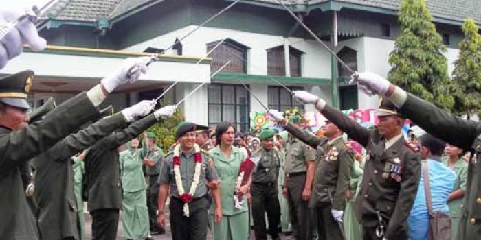 Letkol Inf Akatoto beserta istri mendapat penghormatan pedang pora, tradisi pelepasan kepemimpinan. foto: intan/ BANGSAONLINE