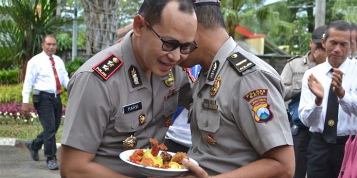 Kapolres Batu AKBP Harviadhi Agung Prathama menyerahkan potongan tumpeng kepada Ipda Suratno usai prosesi kenaikan pangkat, Senin (2/3).