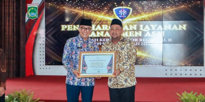 Bupati Gresik Fandi Akhmad Yani (kanan) menerima penghargan dari BKN Kanreg II. Foto: Ist.