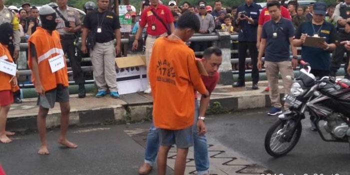 ADY sang eksekutor nyawa Suyono memperagakan penusukan di jembatan kawasan Pasar Induk Gadang, Selasa (09/04). foto: IWAN/ BANGSAONLINE