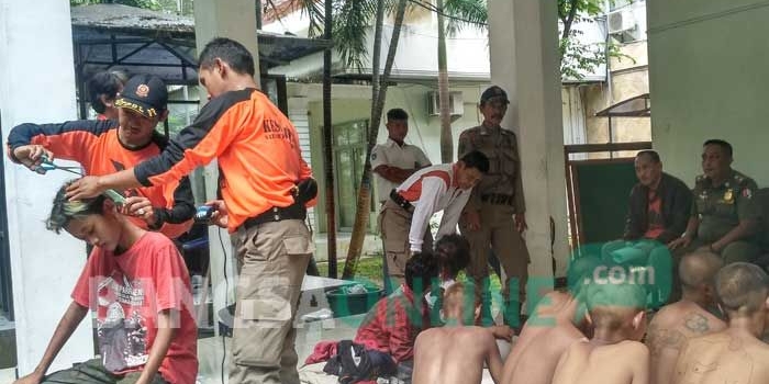 Para siswa yang ketahuan bolos sekolah digunduli oleh petugas Satpol PP. foto: EKY NURHADI/ BANGSAONLINE