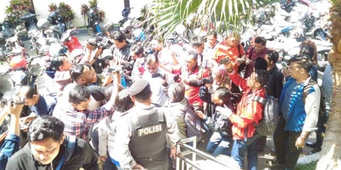 M Arif Wicaksono dikerubuti wartawan saat datang ke Mapolres Makota. foto: IWAN IRAWAN/ BANGSAONLINE