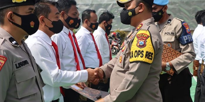 Kapolres Ngawi, AKBP. Dwiasi Wiyatputera memberikan penghargaan kepada 14 anggotanya di halaman Mapolres, Senin (26/9/2022).