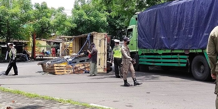 Petugas Polsek Tandes dibantu Satpol PP sedang melakukan pengamanan di lokasi truk terguling. foto: NANANG FACHRUROZI/ BANGSAONLINE